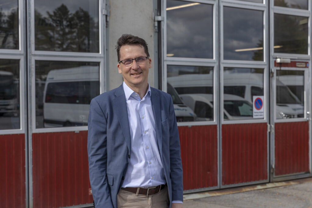 Nordic Bus Groupin edustaja hallien edustalla – yritys siirtyi Excel-pohjaisesta HSEQ-työstä PRO24 HSEQ-järjestelmään